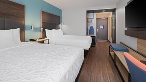 A hotel room with two beds, a desk, a TV, and a shower area. - Tru By Hilton Miramar (Miramar)