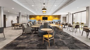 A modern, well-lit lounge area with multiple seating options, including sofas, chairs, and tables.