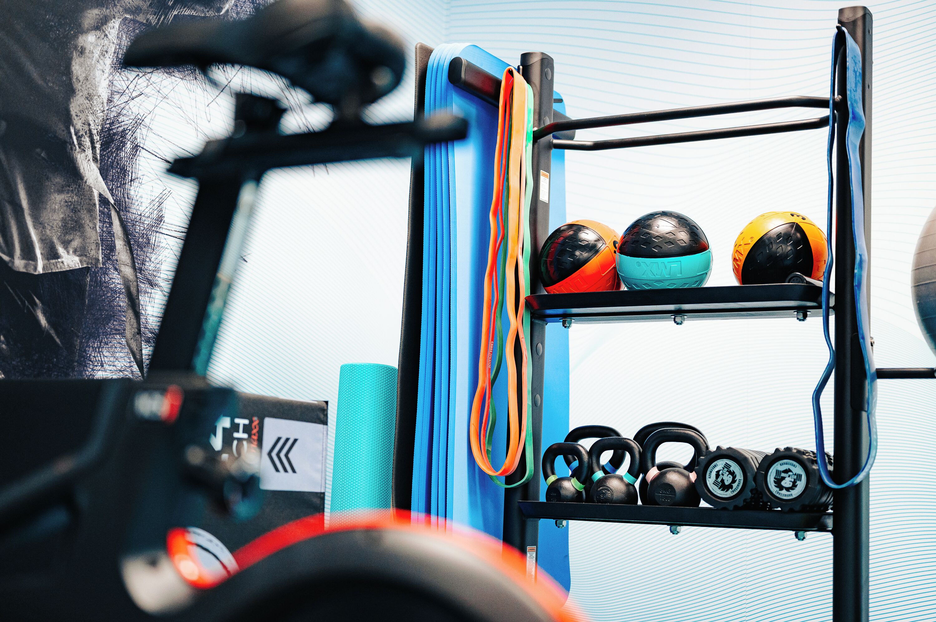 A gym with exercise equipment, including kettlebells and medicine balls on a rack.