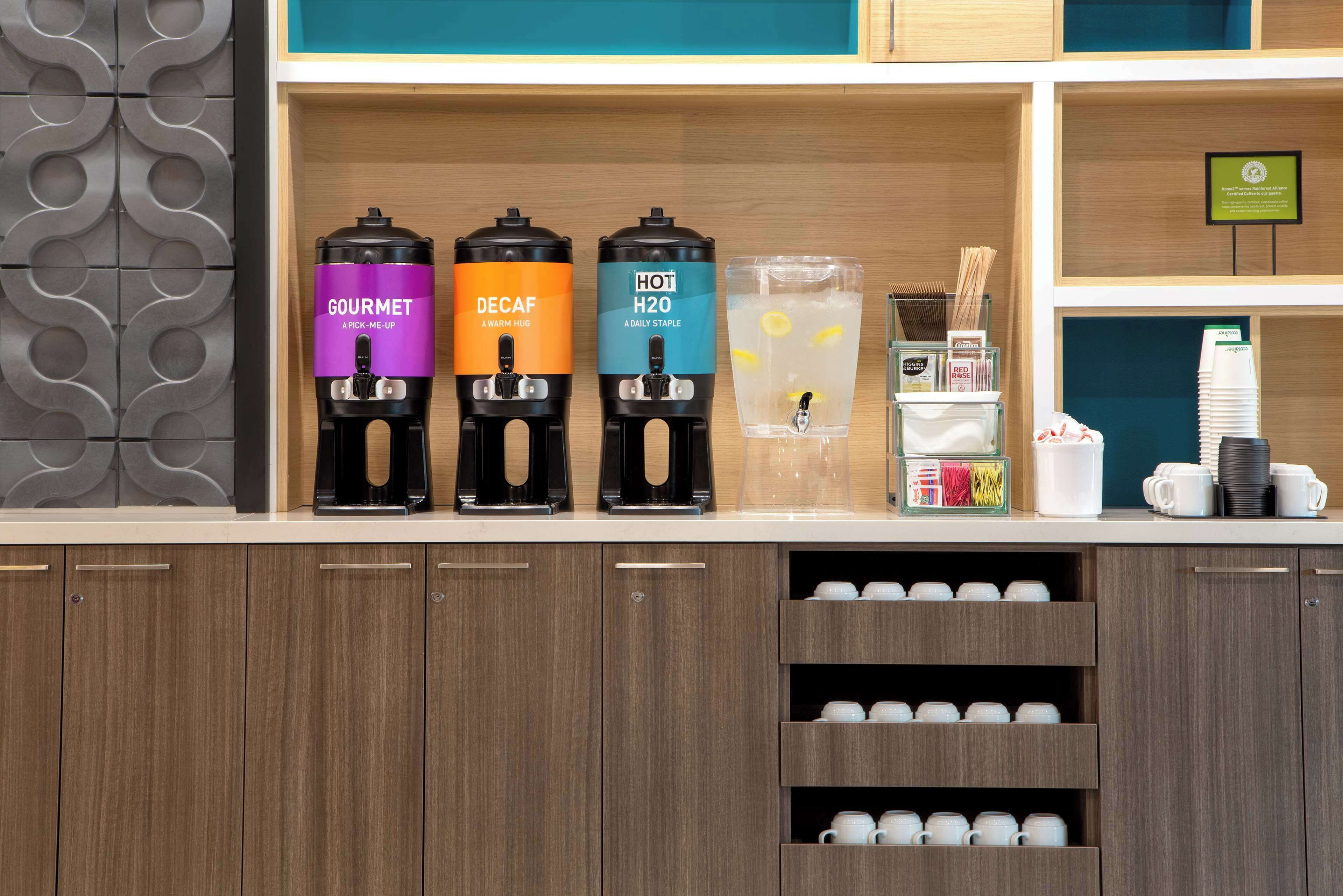 A beverage station with three dispensers labeled 'GOURMET', 'DECAF', and 'HOT H2O'.
