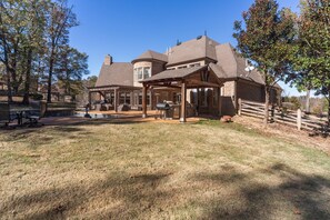 A large house with a covered patio, a barbecue area, and a fenced yard. - Tennessee Modern Manor (Eads)
