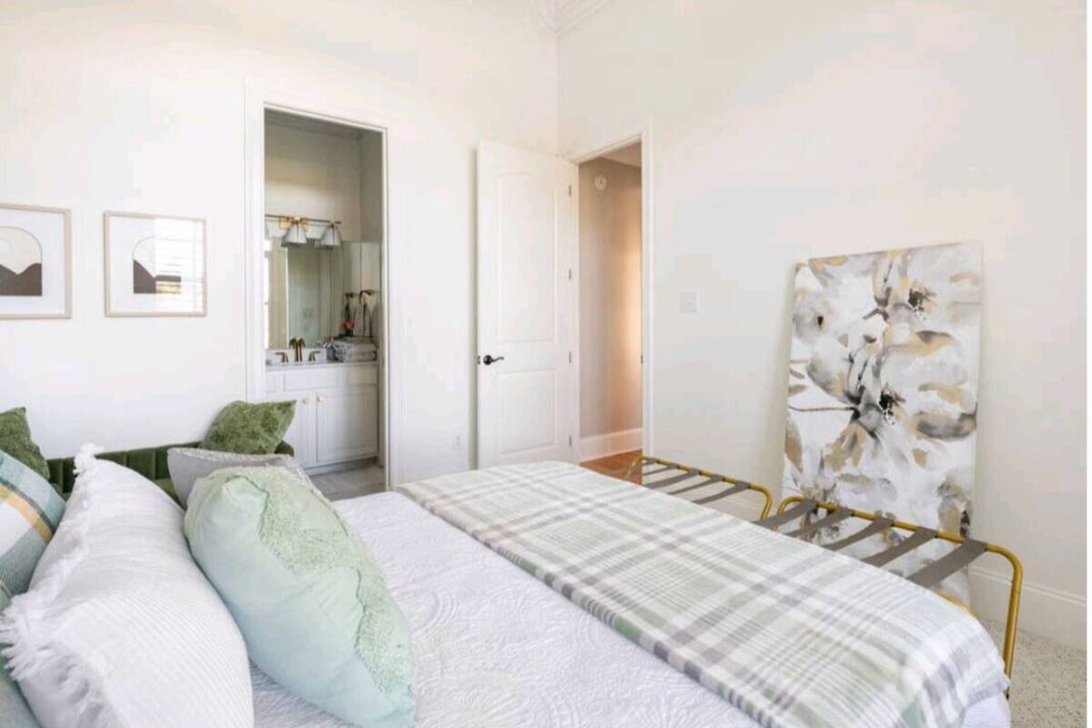 A bedroom with a bed, a wardrobe, a door, and a painting on the wall.