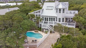 A large house with a swimming pool, surrounded by trees and a hilly landscape. - Vast Luxurious Home in Gated Community + Pool (Seacrest)