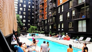 Une piscine intérieure entourée d’immeubles à plusieurs étages dotés de balcons.