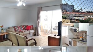 A hotel room with a sofa, dining table, chairs, a kitchen area, and a bathroom. - Temporada Royal Park Caldas Novas 3q (Caldas Novas)