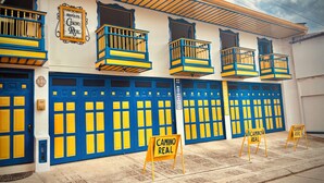 A building with multiple blue and yellow doors, balconies, and signs indicating 'Camino Real'. - Hospedaje Camino Real  (Salento)