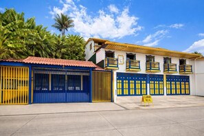 Ein Gebäude mit rotem Ziegeldach, blauen und gelben Türen und einem Schild mit der Aufschrift 'CAMINO REAL'.