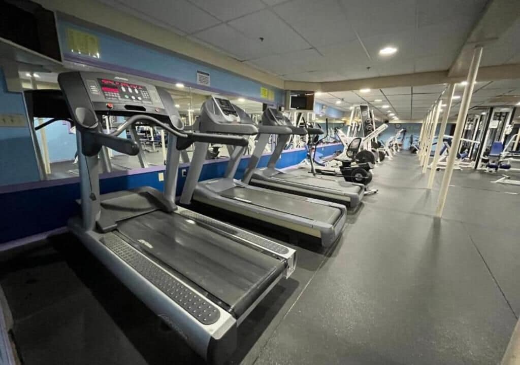 A gym with multiple treadmills and exercise equipment.