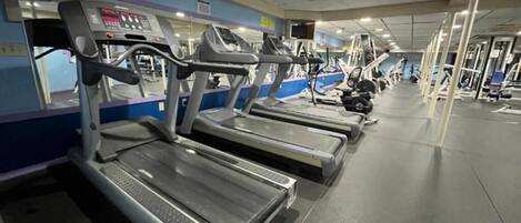 A gym with multiple treadmills and exercise equipment.