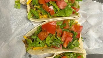 Three tacos on a checkered surface.
