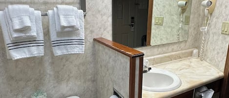 Une salle de bain équipée de toilettes, d’un lavabo et d’un porte-serviettes.