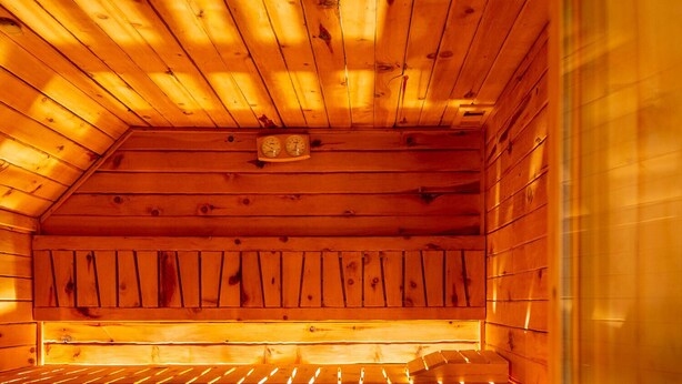A sauna with wooden benches and a sloped ceiling. - PM7        (Castello Cabiaglio)