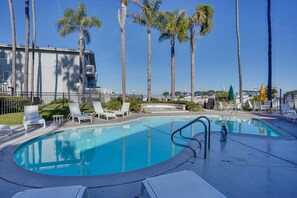 Ein Pool mit Liegestühlen und Palmen.