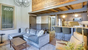A modern living room with a grey sectional sofa, a wooden coffee table, and a chandelier. - Mountain-View Condo in Brian Head w/ Private Sauna (Brian Head)