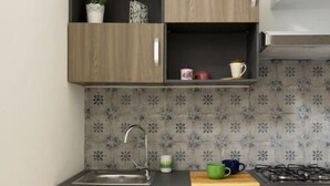 A compact kitchen with wooden cabinets, a built-in oven, and a patterned backsplash. - STAR POLITEAMA APARTMENT, IN CENTERideal for family or business trips. (PALERMO)