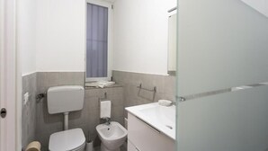 A compact bathroom with a toilet, bidet, and a sink. - STAR POLITEAMA APARTMENT, IN CENTERideal for family or business trips. (PALERMO)