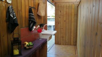 A wooden interior with a sink, a mirror, and a towel rack.
