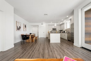 A modern kitchen with a central island, white cabinetry, and stainless steel appliances. - The Green Pearl 2Bed/2Bath Venice Beach/MDR/SM (Marina del Rey)