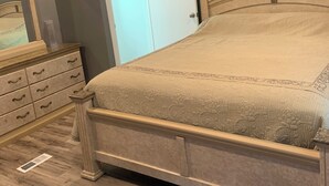 Un dormitorio con cama, cómoda, espejo y ventilador de techo.