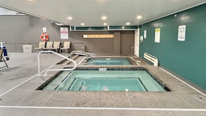 An indoor swimming pool with two lanes, safety signs, and a lifeguard chair. - The Grizz- AC, Pool, Sauna, Gym, Near Resort (Killington)