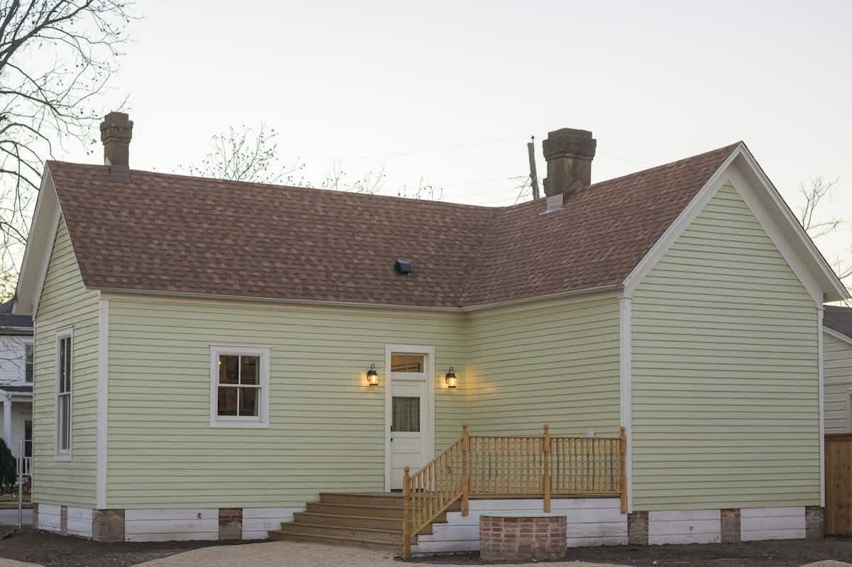 A single-story house with a front porch, a chimney, and a front door.