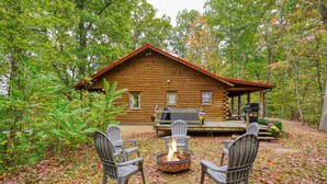 A log cabin with a fire pit and outdoor seating. - Cozy Casa Carezza Log Cabin, Logan, Ohio, Pet Friendly, Sleeps 6 (Logan)