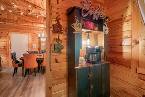 A wooden interior with a coffee station featuring a Keurig machine, a coffee pot, and a sign that reads 'Coffee'.