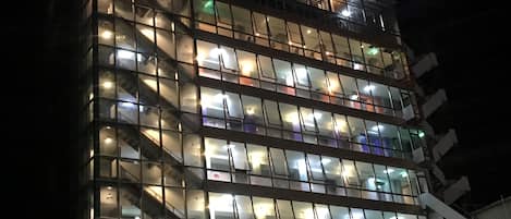 A multi-story hotel with a modern glass facade and illuminated windows.