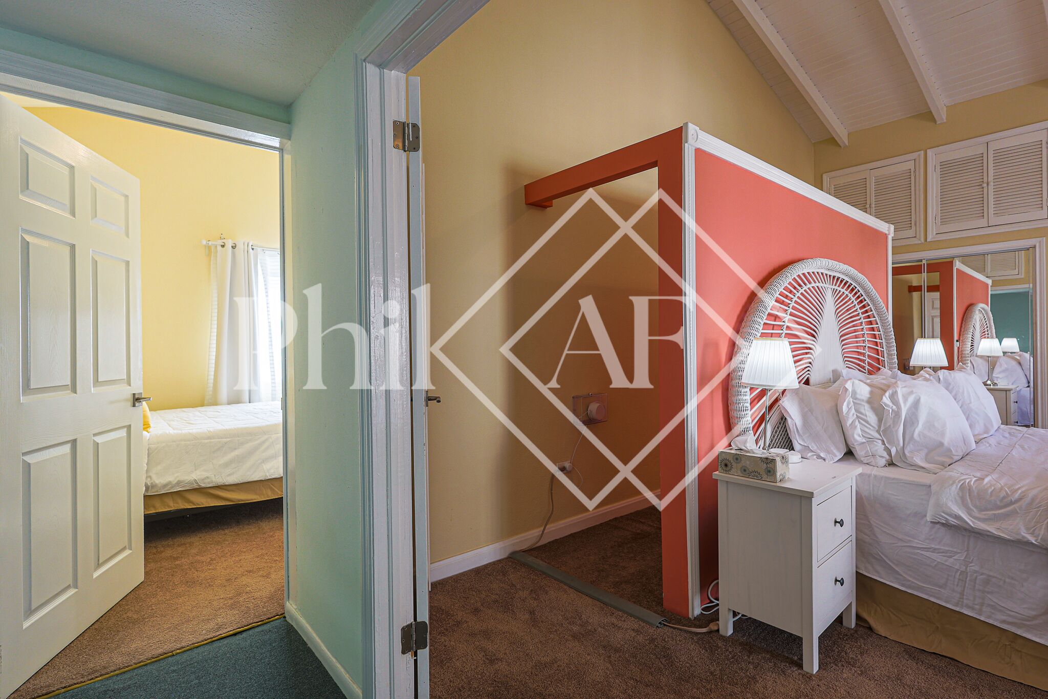 A bedroom with a bed, nightstand, and a mirror.