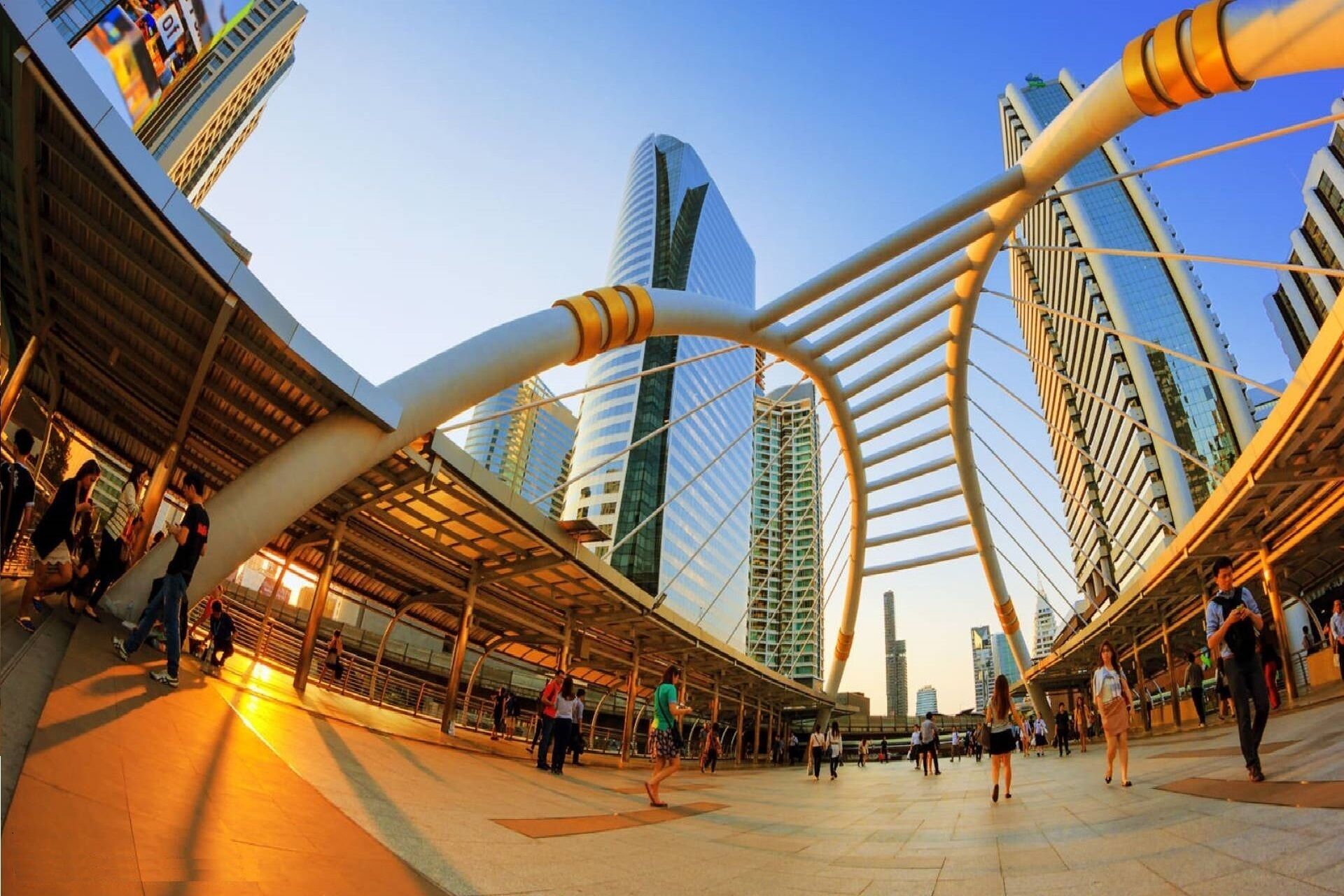 A modern urban plaza with a distinctive cable-stayed bridge structure, surrounded by high-rise buildings.
