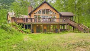 A large wooden house with a balcony and a staircase leading to a deck. - Cozy Wisconsin Cabin w/ Deck, Kayaks & Lake Views! (Hayward)