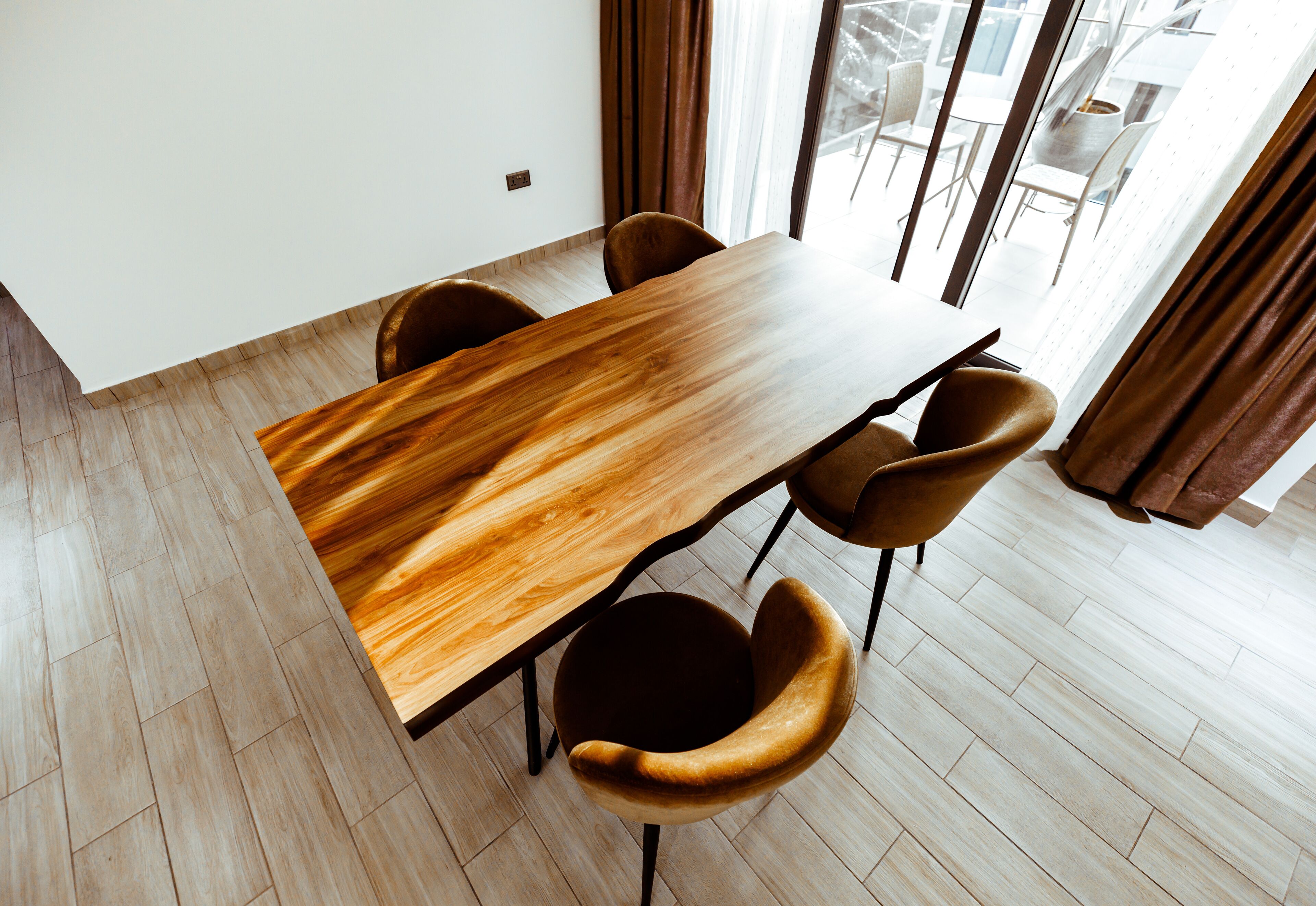 Un comedor moderno con una mesa de madera y cuatro sillas.