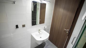 A bathroom with a white sink, a mirror, and a wooden door.