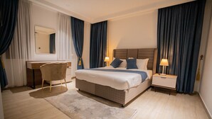 Een moderne hotelkamer met een groot bed, een bureau en een stoel.