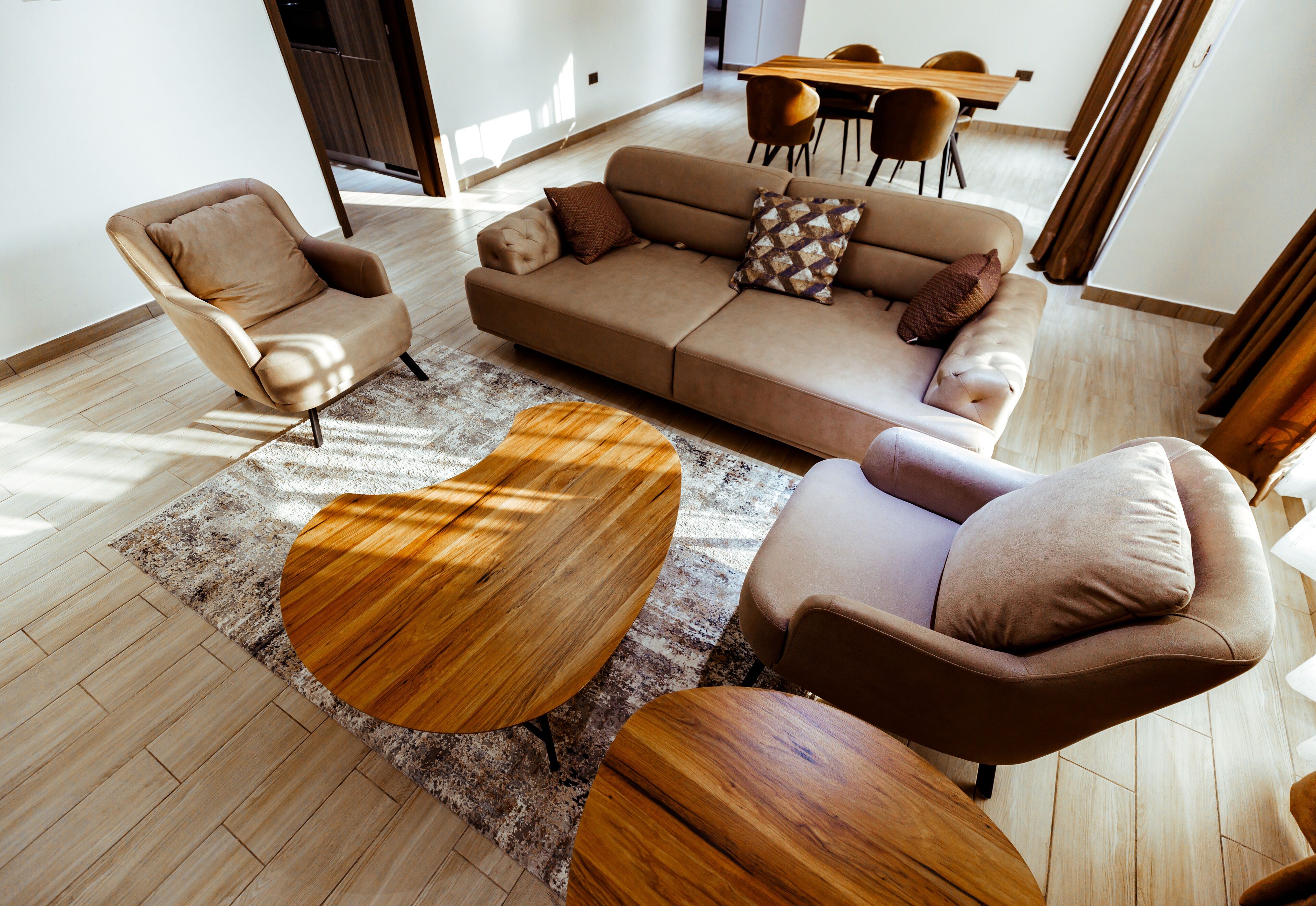A modern living room with a sofa, armchairs, and a coffee table.