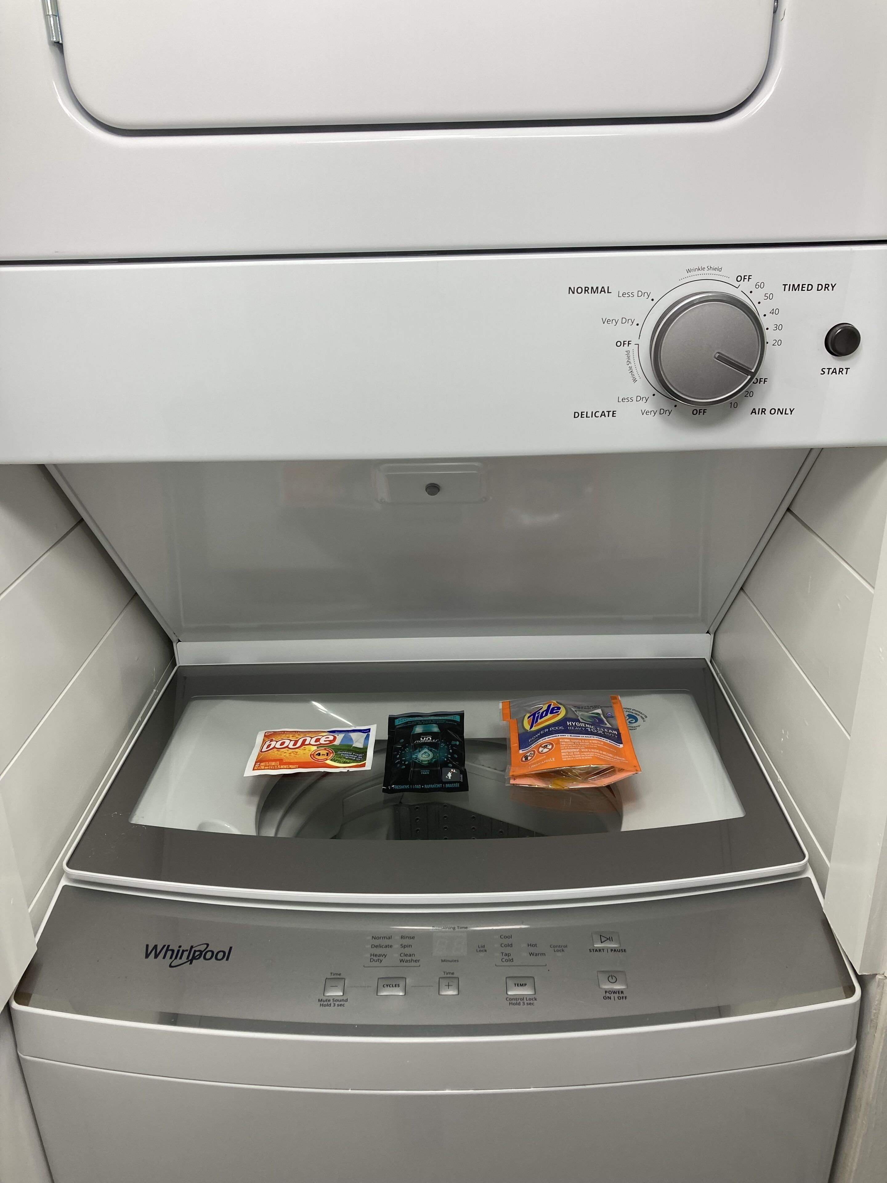Une machine à laver Whirlpool dotée d’un panneau de commande, d’un programmateur et d’un compartiment à lessive.