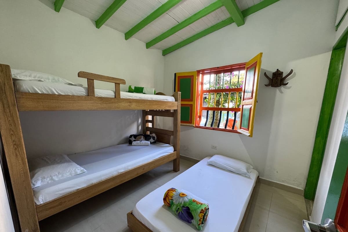 A bunk bed room with a window and a door.