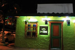 A small building with a green exterior and a sign that reads "Casa Motel las Palmas."