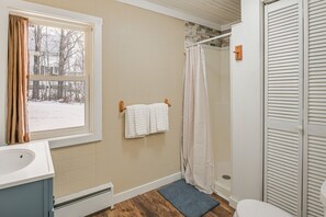 Ein Badezimmer mit Fenster, Dusche, Toilette und Waschbecken.