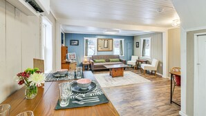 A spacious living room with a wooden dining table, a sofa, and a coffee table. - Maine Vacation Rental < 1 Mi to Portage Lake Beach (Portage Lake)