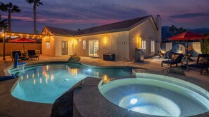 A swimming pool with a hot tub, outdoor seating, and a house with string lights. - The Blue Cactus in Palm Springs: Family-Friendly, Pool/Spa, Game Room & Fire-Pit (Palm Springs)