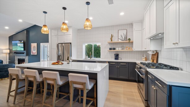 A modern kitchen with a central island, bar stools, a built-in stove, and pendant lighting. - The Blue Cactus in Palm Springs: Family-Friendly, Pool/Spa, Game Room & Fire-Pit (Palm Springs)
