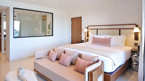 Una habitación de hotel moderna con una cama grande, un sofá, una pequeña mesa y un espejo.
