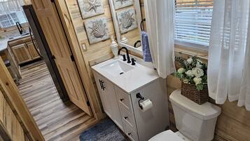 A wooden interior with a white sink, cabinet, and toilet.