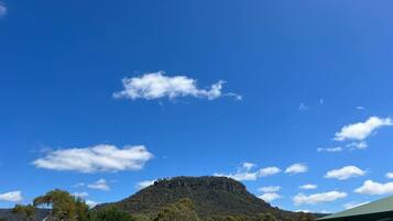 Ein Berg mit blauem Himmel und vereinzelten Wolken.