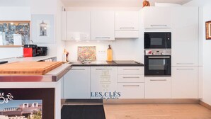 A modern kitchen with white cabinets, a black oven, and a sink.