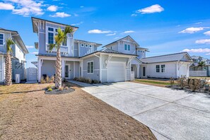 A residential area with multiple houses, a driveway, and a well-maintained lawn.