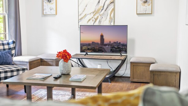 A modern living room with a large flat-screen TV, a coffee table, and a sofa. - East Point Retreat Near ATL Airport (East Point)