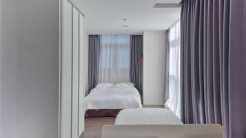 Una habitación de hotel moderna con una cama grande, una cama más pequeña y una zona de estar.