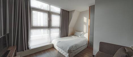 Ett modernt hotellrum med en säng, en soffa och ett skrivbord.